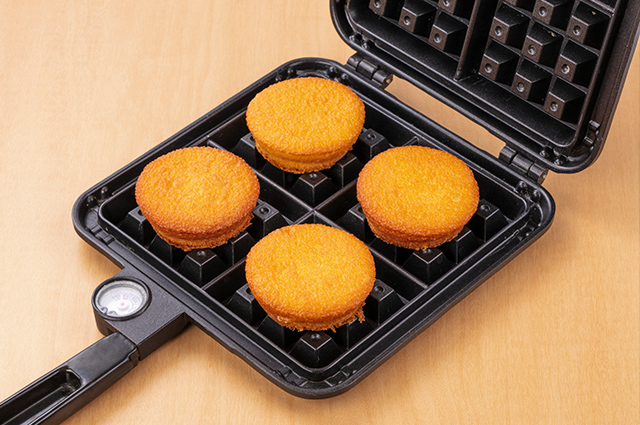 ワッフルメーカーにカスタードケーキをのせる。